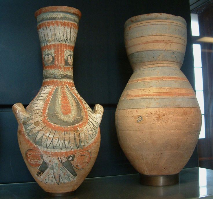 two vases sitting on top of a shelf next to each other