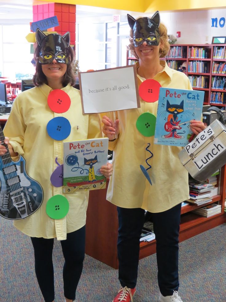 two women in yellow shirts holding up signs and guitar shaped magnets ...