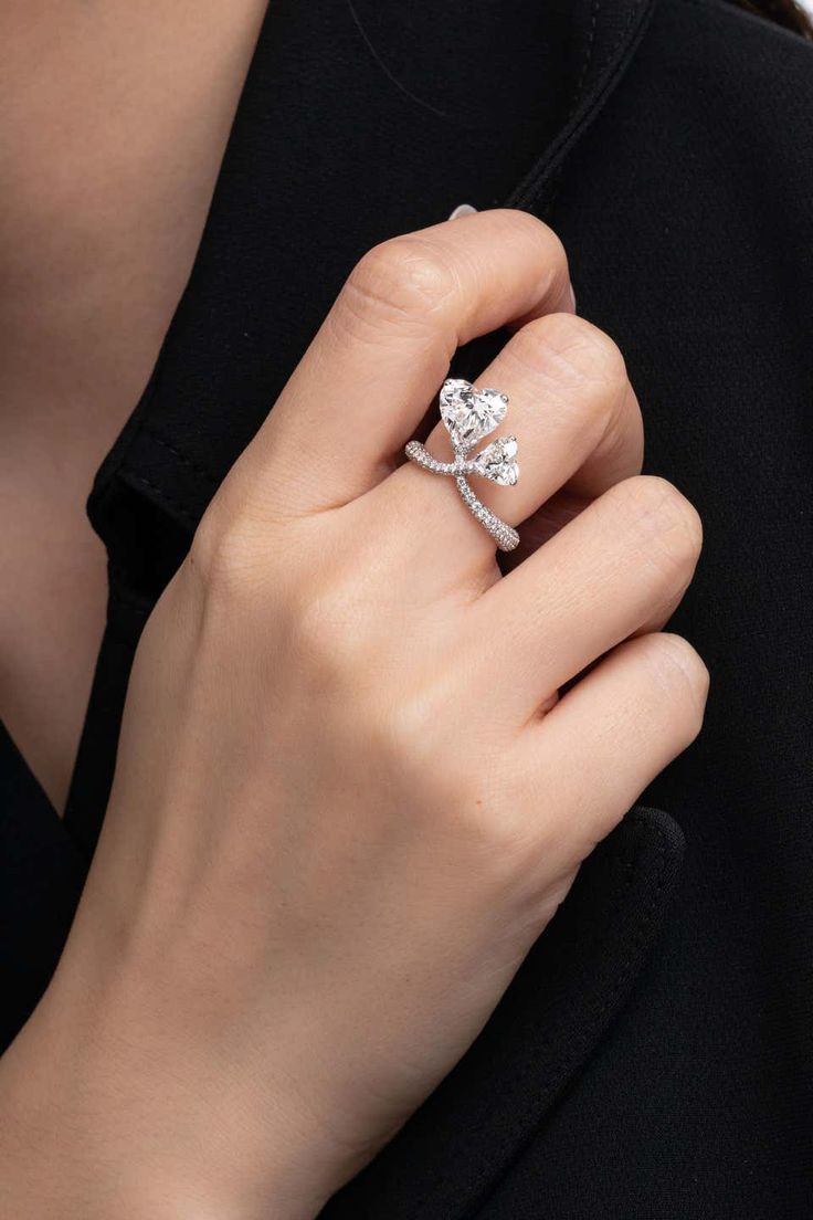 a woman's hand wearing a diamond ring