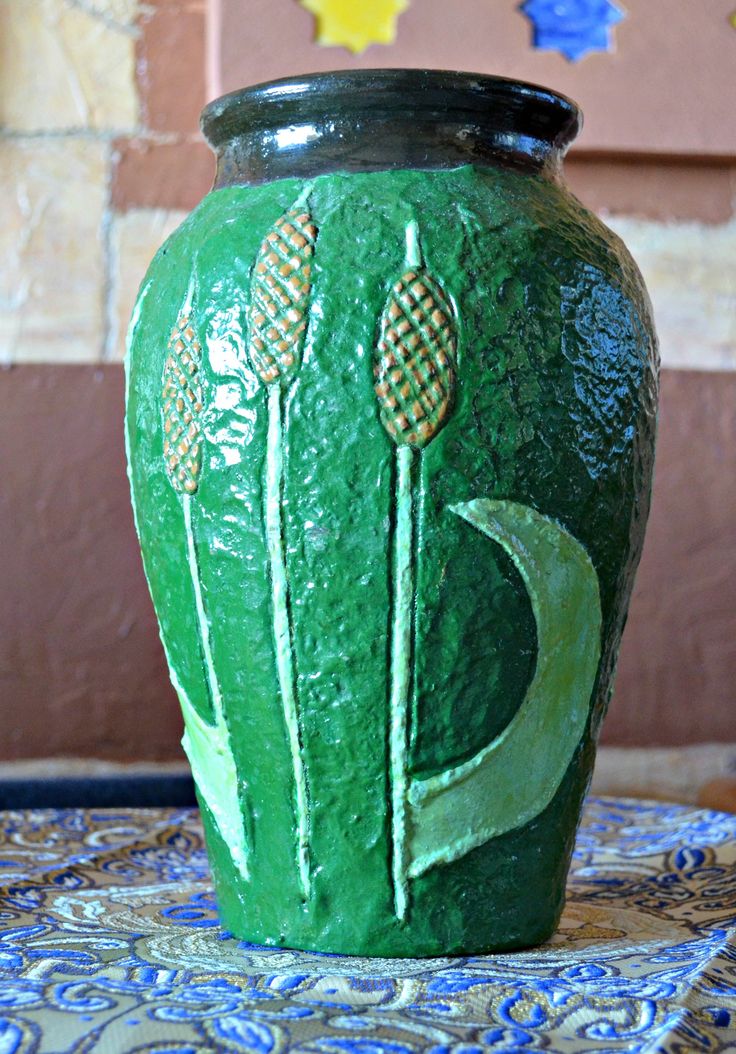 a green vase sitting on top of a table