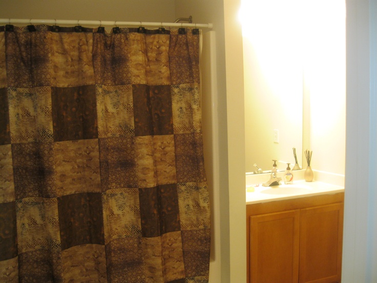 a bathroom with a checkered shower curtain next to a sink