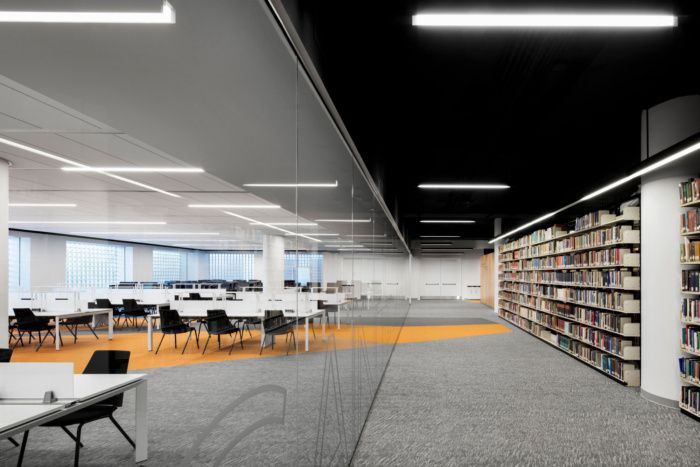 an empty library with tables, chairs and bookshelves in the middle of it