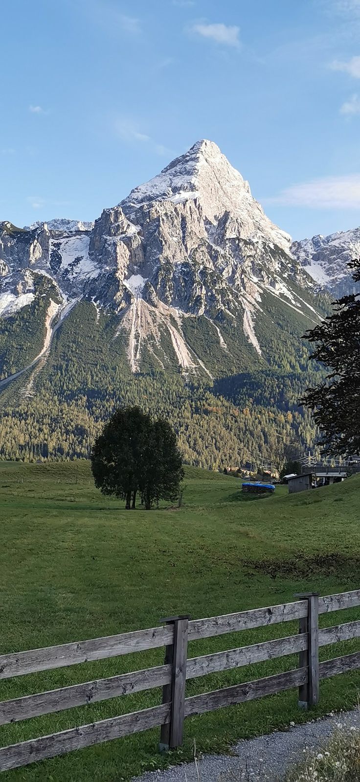 a wooden fence in front of a large mountain