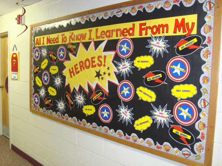 a bulletin board is hanging on the wall in a school hallway that reads, all i need to know i learned from my hero