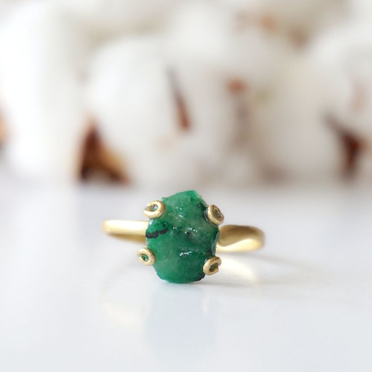 Dark green and gold create an emerald ring that sings with elegance and stands for bravery. The adjustable ring easily fits various ring sizes. The 14k gold filled metal setting creates a long-lasting and hypoallergenic ring. Each handmade pair uses a three step adhering process to guarantee durability and quality, Hypoallergenic material guarantees no reaction when you wear them. As no raw stone is the same, each emerald ring has a slightly different shape and size guaranteeing uniqueness and i Green Open Ring For Promise, Adjustable Emerald Wedding Ring May Birthstone, Adjustable Wedding Emerald Ring For May Birthstone, Green Dainty Jewelry For Promise, Yellow Gold Emerald Jewelry, Green Emerald Open Ring Stackable Rings, Green Emerald Stackable Open Rings, Adjustable Emerald Wedding Ring, Adjustable 14k Gold Emerald Ring