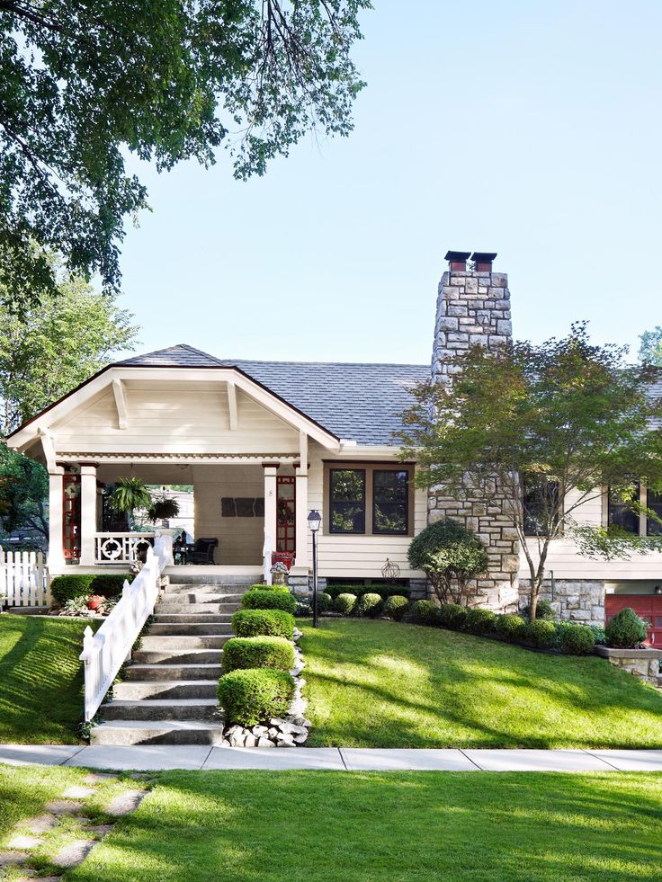 a house with steps leading up to the front door and landscaping on both sides of it