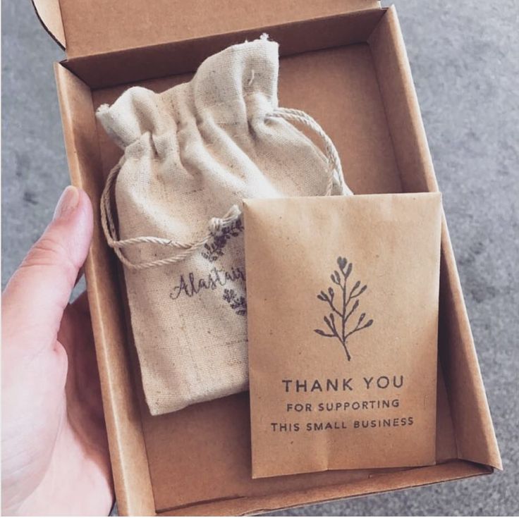 someone is holding a small gift bag in a box that says thank you for supporting this small business