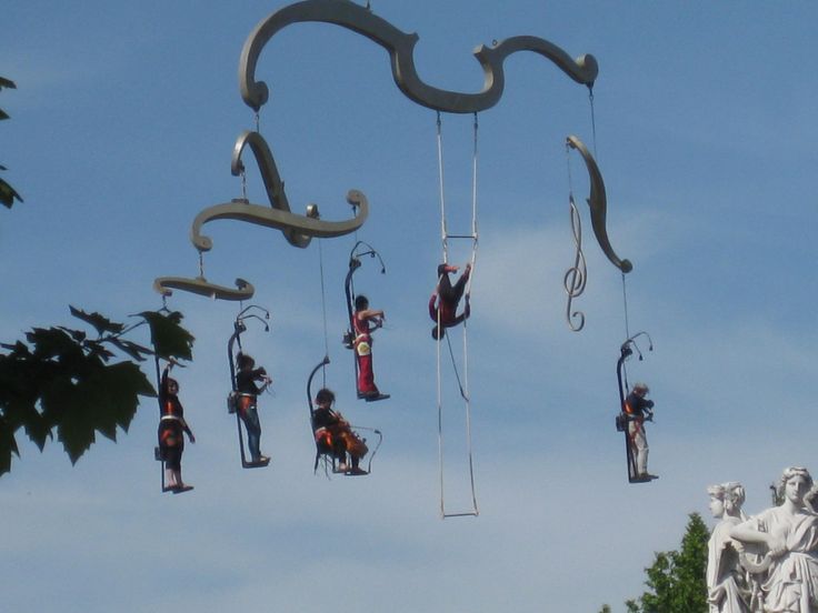 some people are doing tricks in the air with their hands and legs attached to ropes