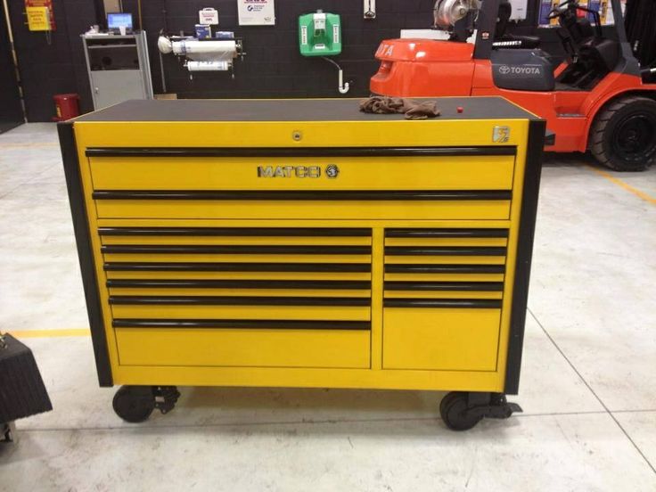 a yellow tool cabinet sitting on wheels in a garage