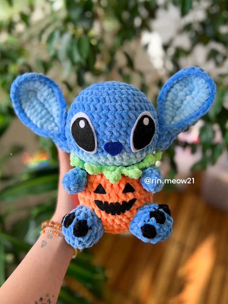 a small crocheted stuffed animal is being held up by someone's hand