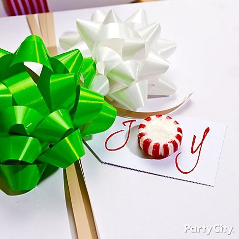 two different types of bows on top of a white table next to a card with the word joy