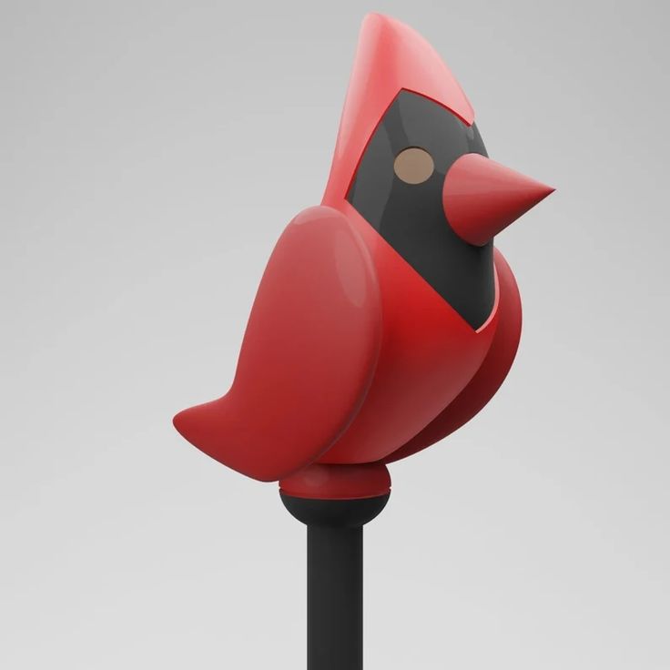 a red bird on top of a black pole