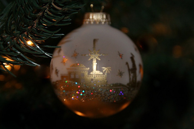 an ornament hanging from a christmas tree in the shape of a church with a cross on it