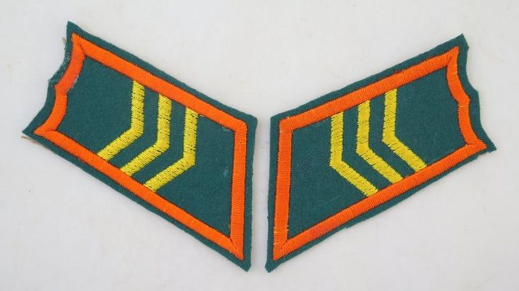 two green and orange patches on a white surface, one has an arrow in the middle