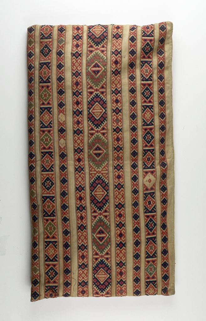 an old rug is hanging on the wall