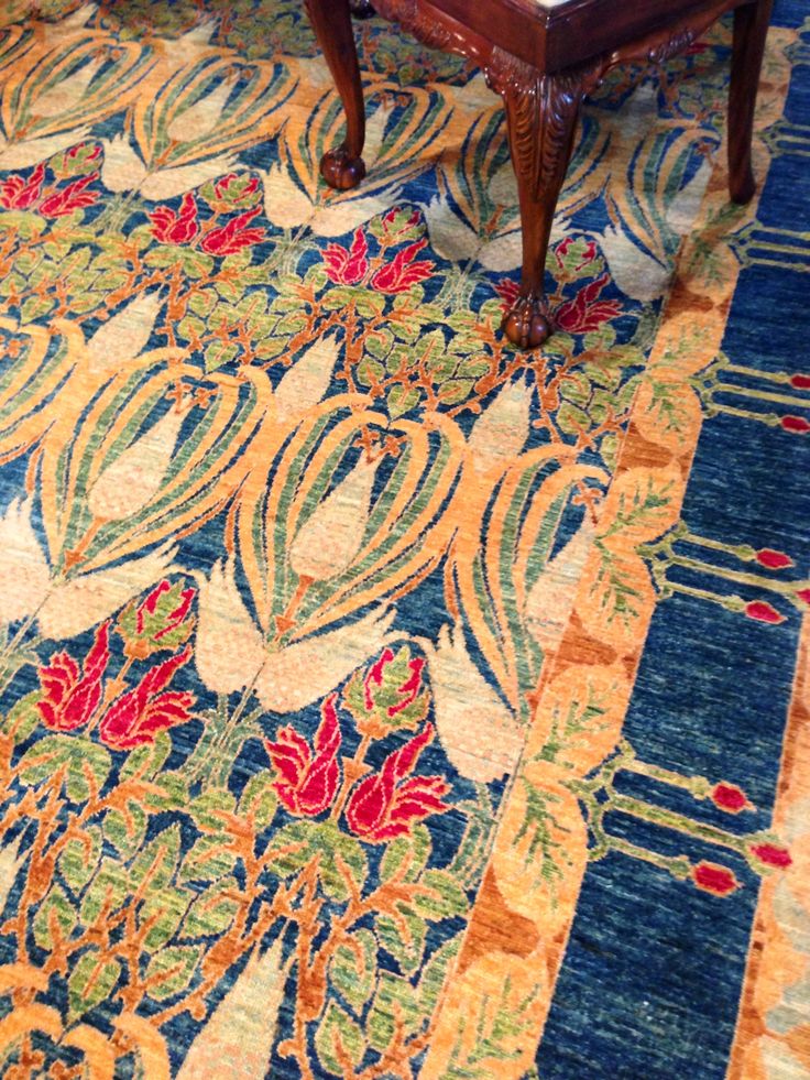 an ornately decorated area rug on the floor in a living room or dining room