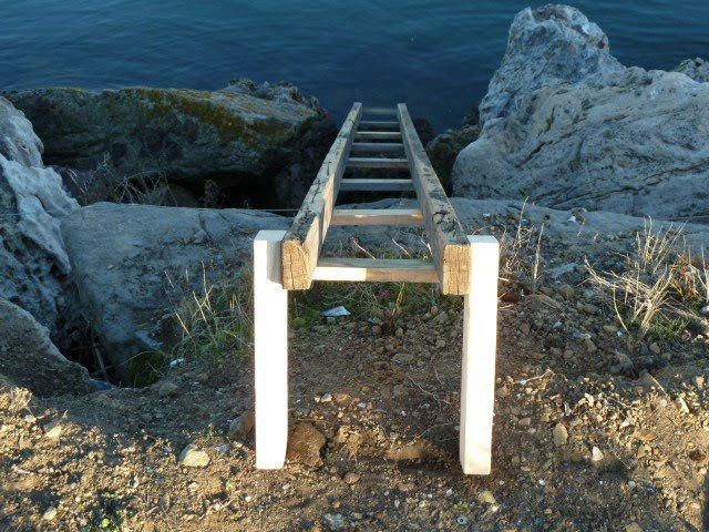 a wooden ladder sitting on top of a rocky beach