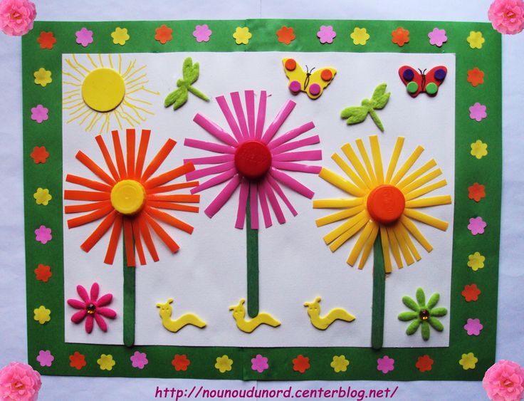 a card with paper flowers and butterflies on the front, surrounded by pom - poms