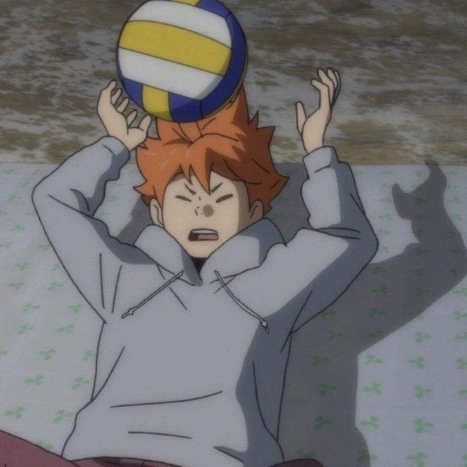 an anime character holding a volleyball ball on his head