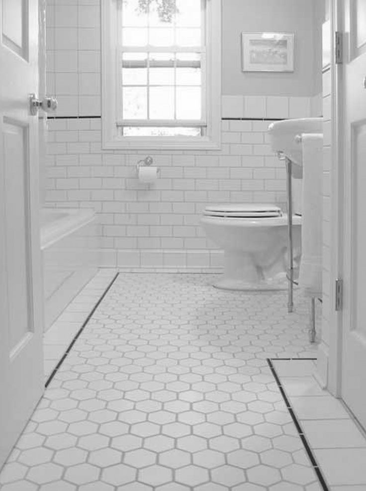 a white toilet sitting next to a bath tub in a bathroom under a window on top of a tiled floor