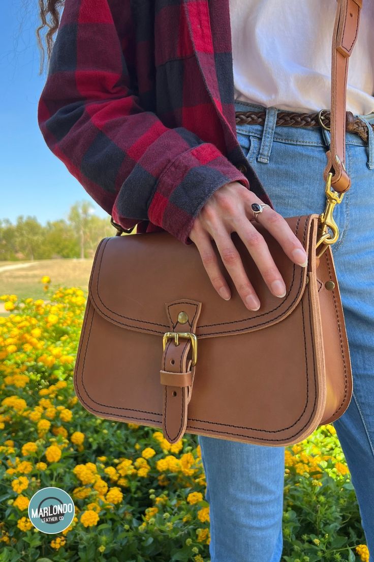 The Marlondo Leather Saddle Crossbody Purse is a vintage inspired saddle bag purse, perfect for weekend adventures and everyday carry. This purse has a belted buckle closure for a timeless chic look. The Saddle Crossbody features an interior pocket and two slot pockets on the bag's exterior: one across the rear of the bag and another just under the main flap. The Saddle Crossbody also comes with an adjustable and removable strap. Classic Leather Shoulder Bag With Buckle Closure, Classic Brown Satchel With Buckle Closure, Timeless Saddle Bag With Adjustable Strap For Everyday, Timeless Everyday Saddle Bag With Adjustable Strap, Classic Flap Shoulder Bag With Buckle Closure, Timeless Saddle Shoulder Bag For Everyday, Timeless Shoulder Saddle Bag For Everyday Use, Classic Brown Saddle Bag With Adjustable Strap, Leather Saddle Shoulder Bag With Buckle