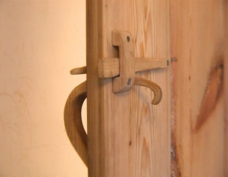 a wooden door handle on the side of a wall