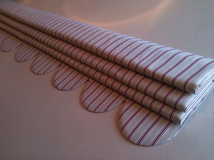 four folded napkins sitting on top of a white table cloth covered in red and white stripes