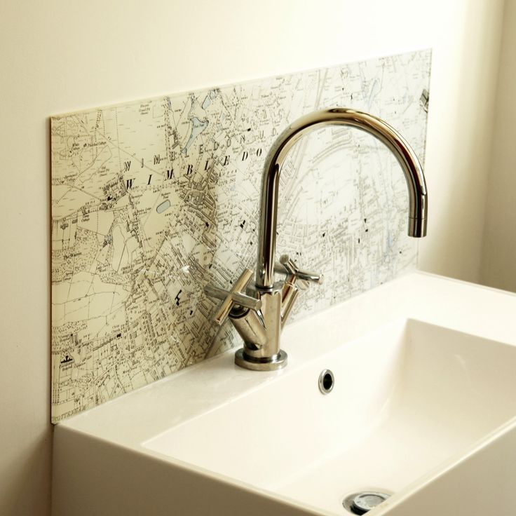 a bathroom sink with a faucet and map on the wall