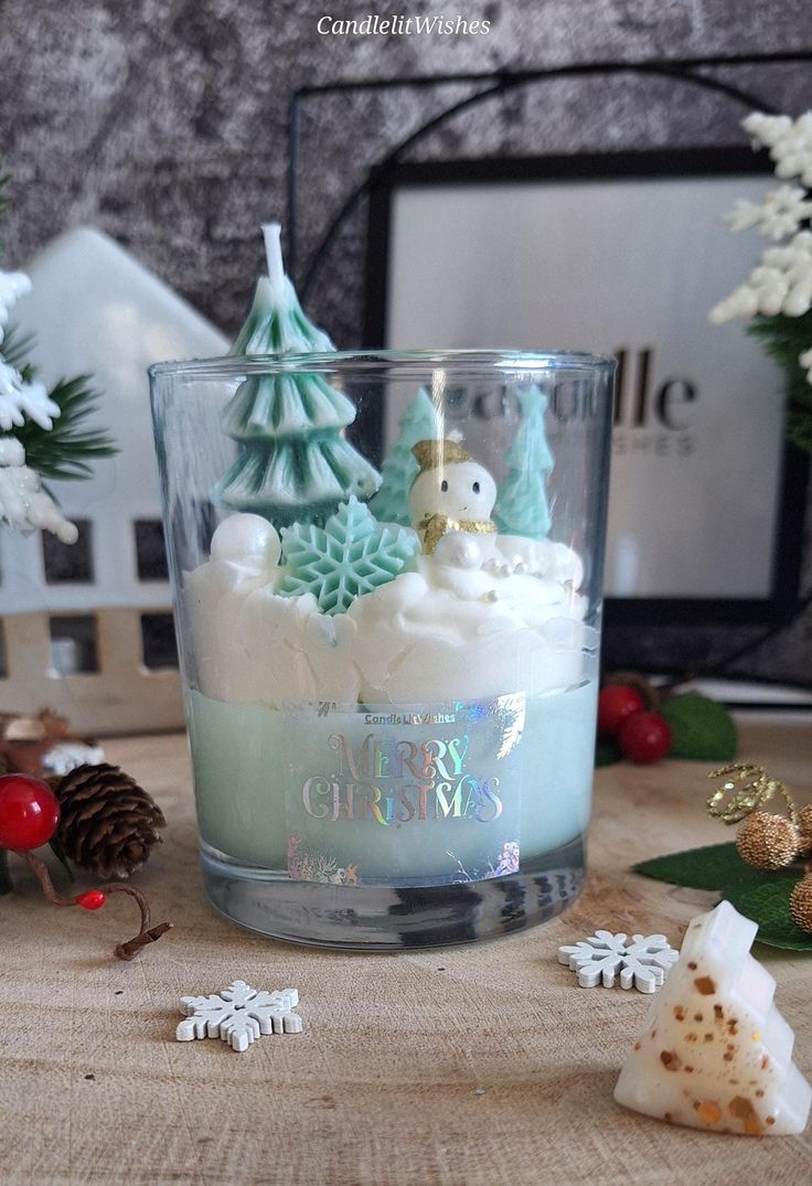 a glass filled with white frosting next to christmas decorations