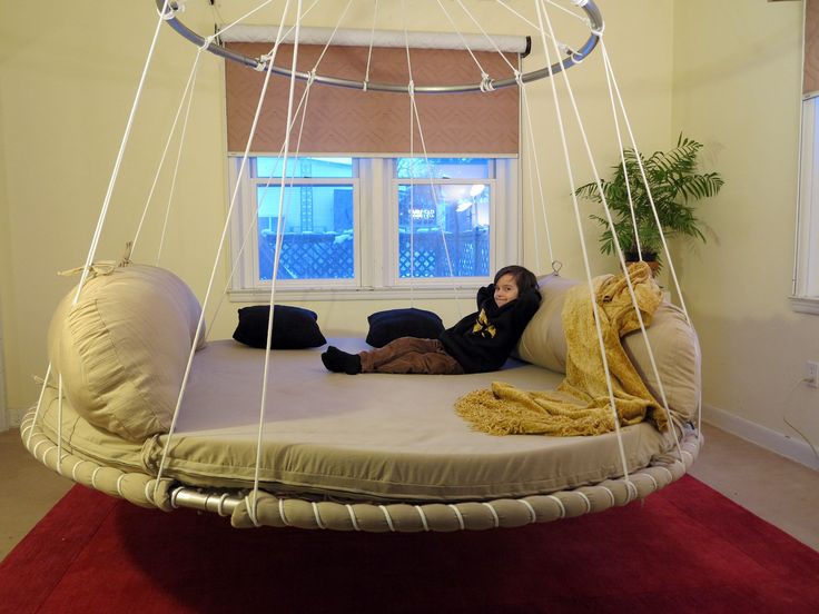 a woman laying on a bed in a room with a red carpet and white walls