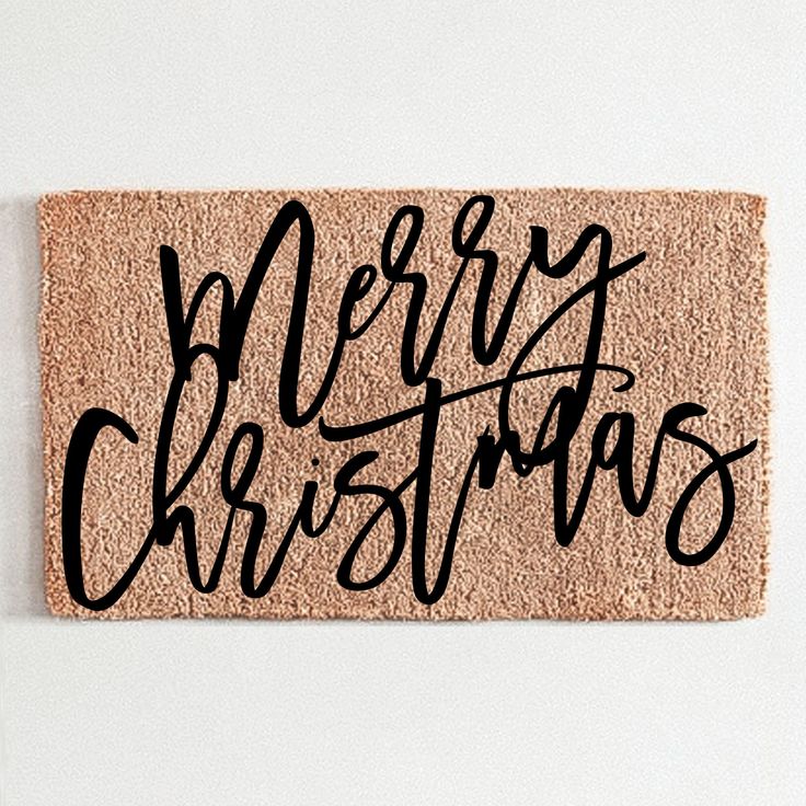 a door mat with the words merry christmas written in cursive black on it