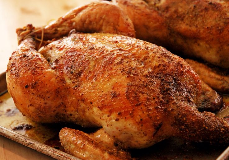 a roasted chicken sitting on top of a pan