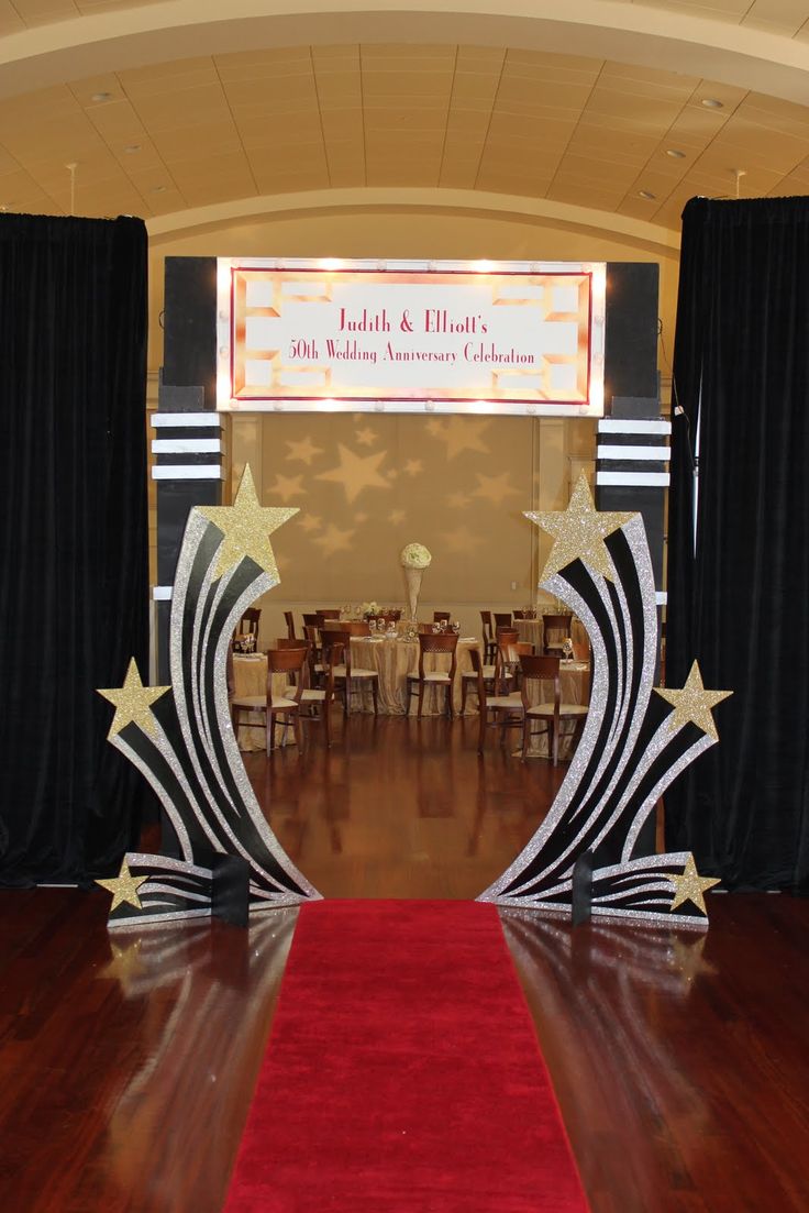 a red carpet is on the floor in front of black drapes with gold stars