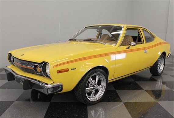 an old yellow muscle car on a black and white checkered floor