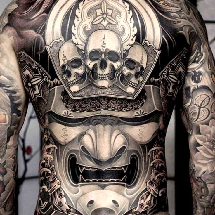 the back of a man with tattoos on his body and head, wearing a mask