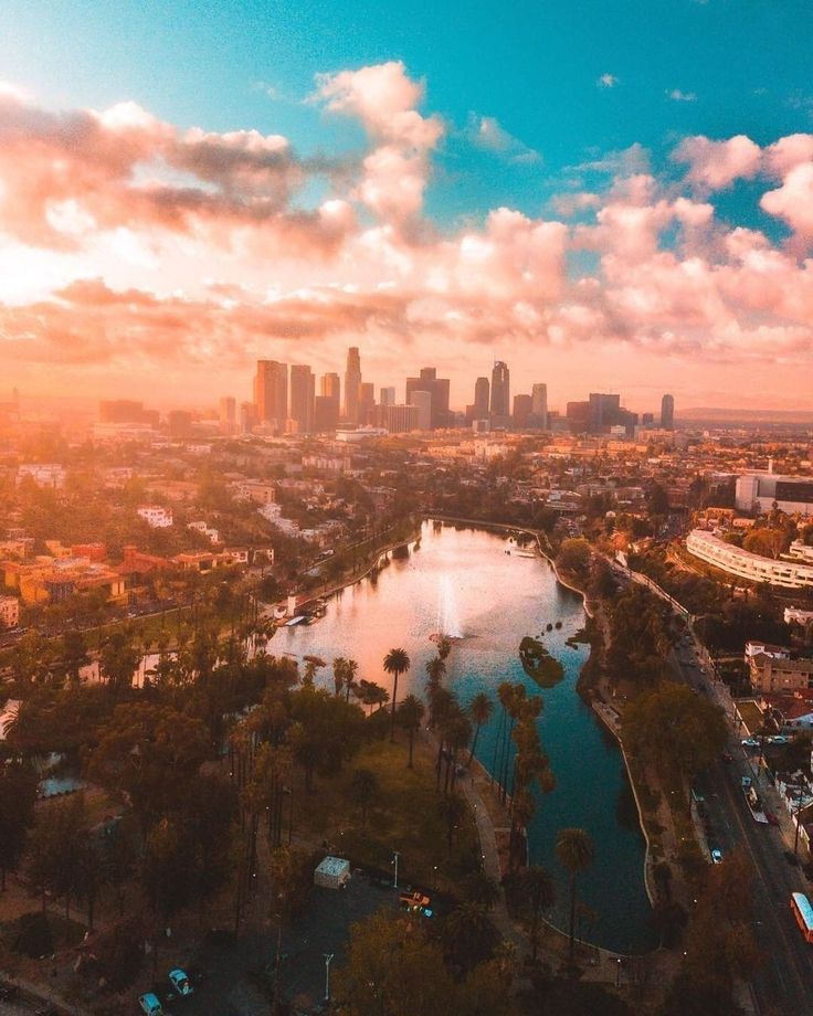 an aerial view of a city and the lake in front of it at sunset or sunrise