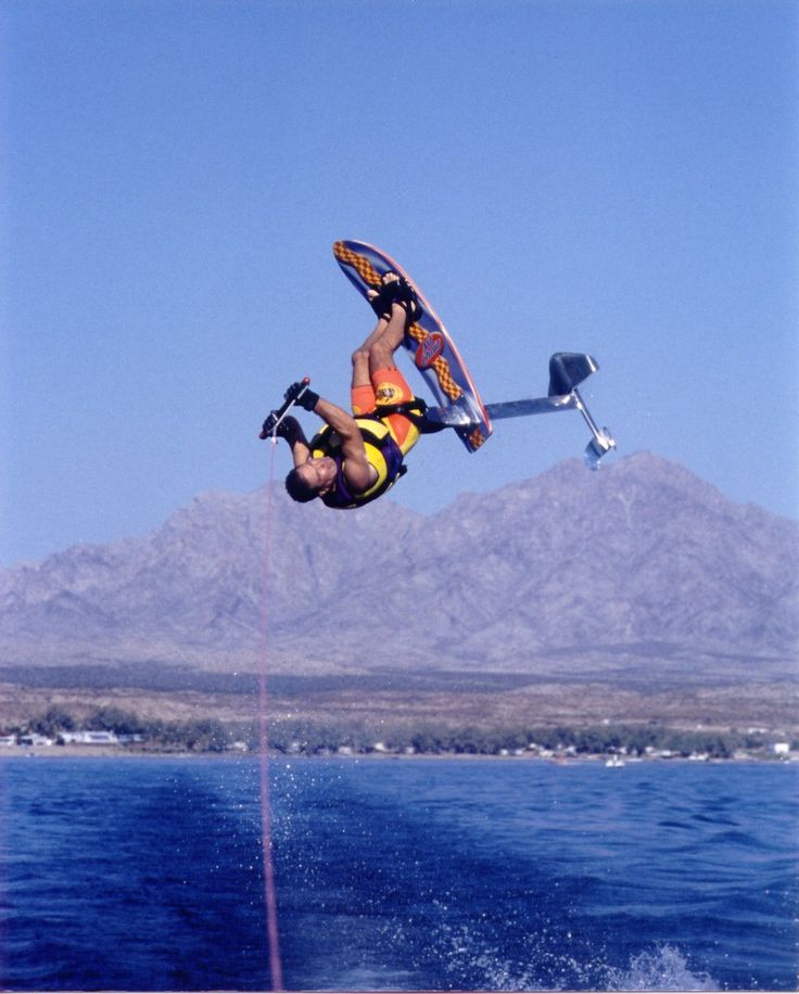 a man flying through the air while riding a wakeboard on top of a body of water