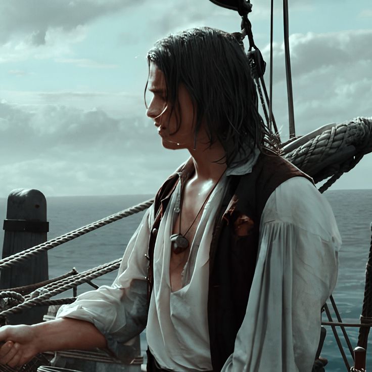 a man with long hair standing on the deck of a ship looking at something in his hand