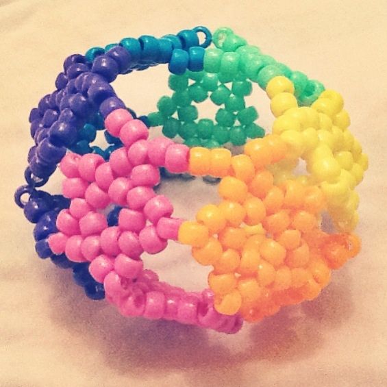 four different colored bracelets sitting on top of a white table next to each other