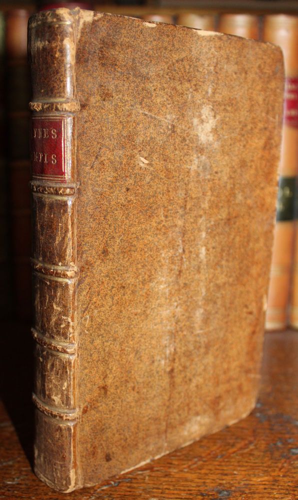 an old book sitting on top of a wooden table next to some bookshelves