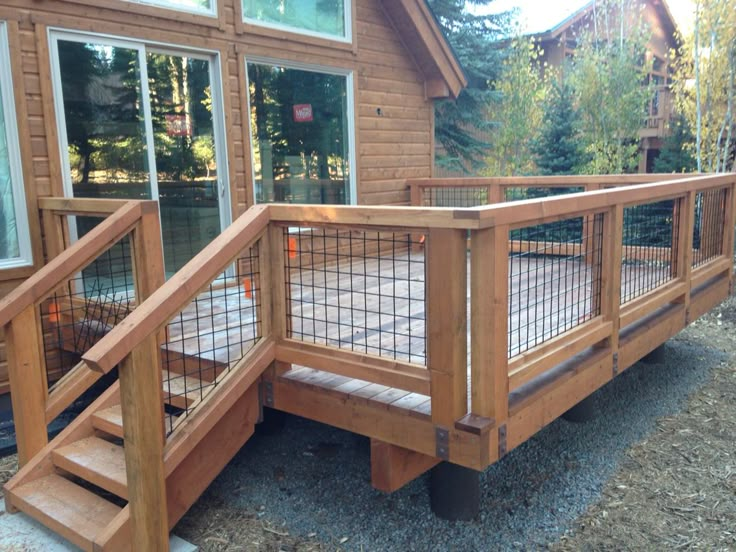 a wooden deck with metal railing and steps