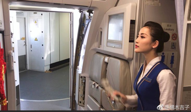 a woman is standing on an airplane looking out the window at another person who is holding something in her hand