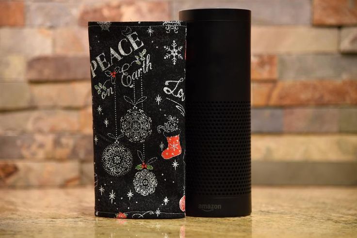 an amazon echo speaker next to a christmas themed case