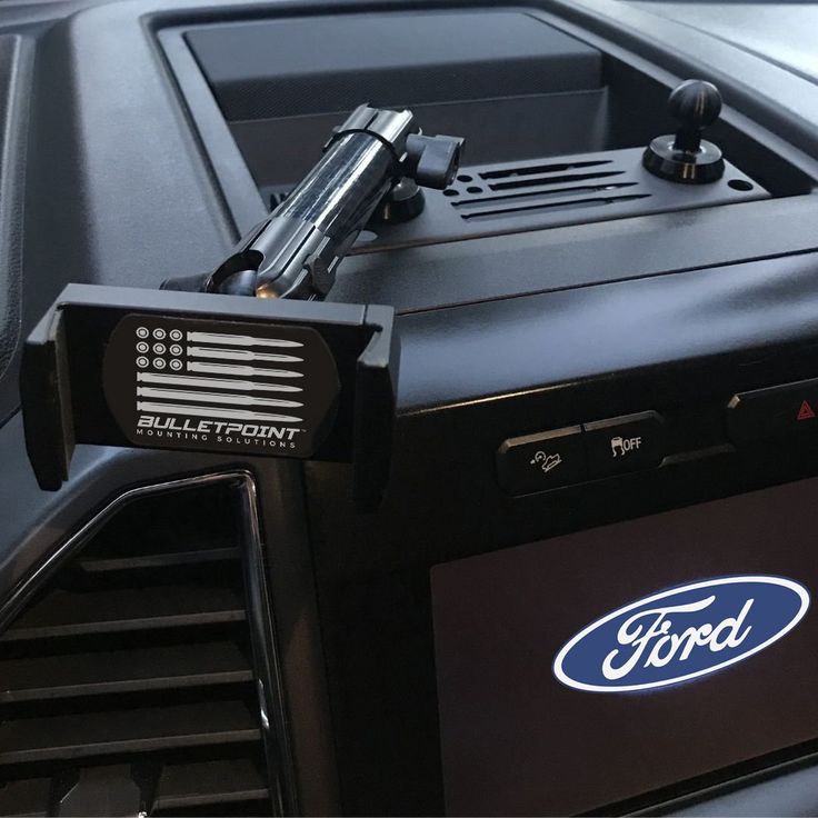 an electronic device mounted to the side of a car's dash board with ford logo on it