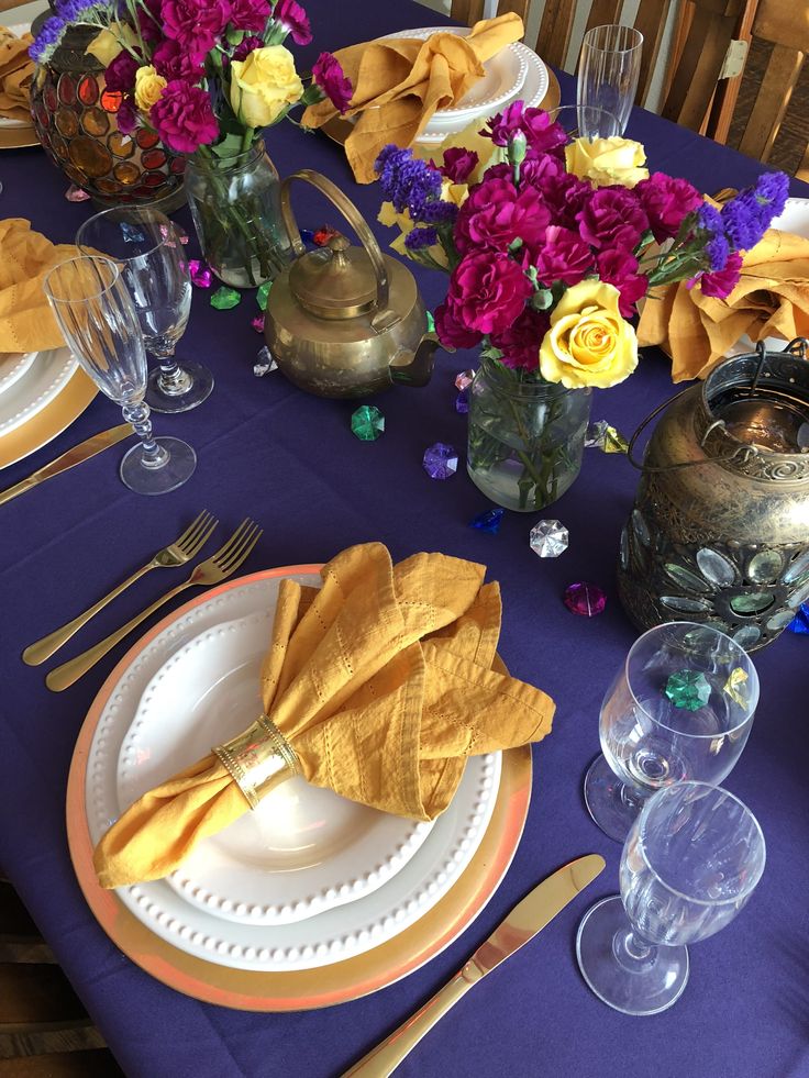 the table is set with purple and yellow flowers