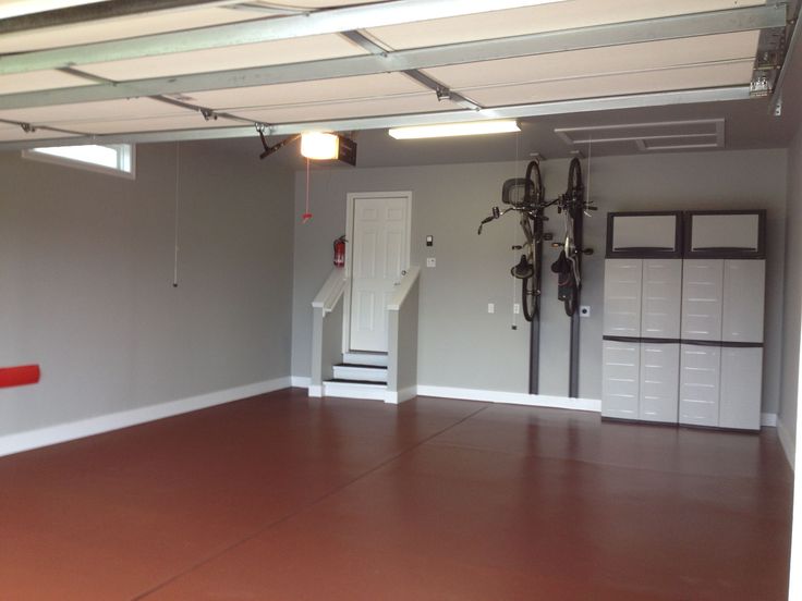 an empty garage with two bikes mounted to the ceiling