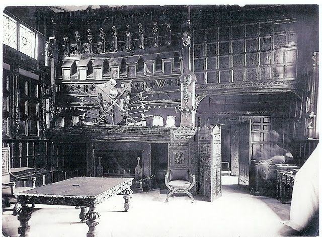 an old black and white photo of a room with many books on the walls, tables in front of them