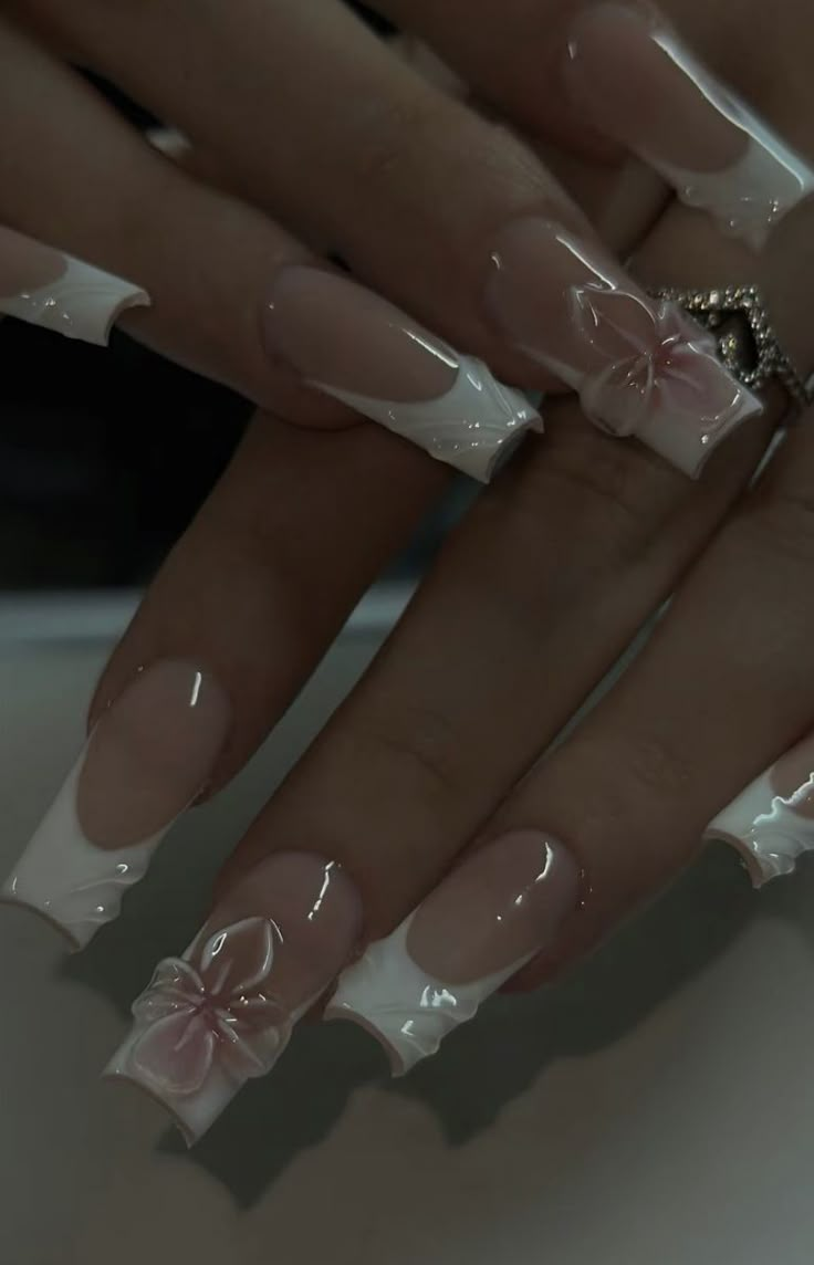 a woman's nails with white and pink designs on them, including bows in the middle