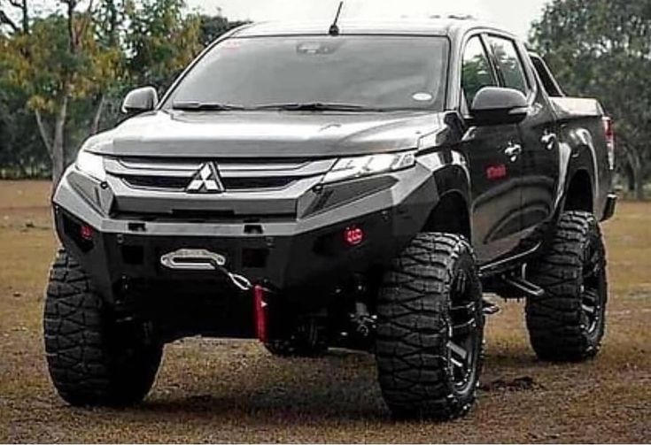 a black truck parked in the middle of a field