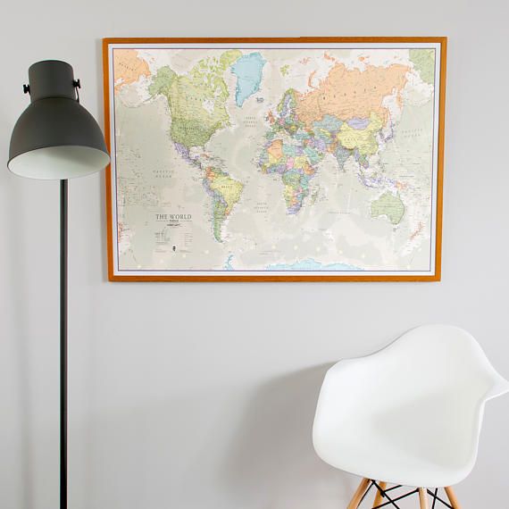 a white chair sitting in front of a large map on the wall next to a lamp